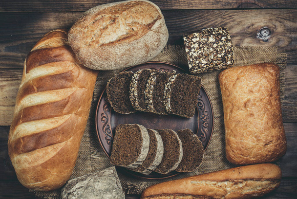 Свіжі хліби з пшеницею і глютеном на дерев'яному столі
 - Фото, зображення