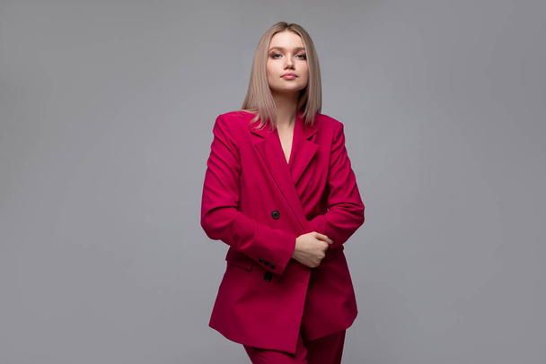 Sexy blonde in a bright raspberry pantsuit - Zdjęcie, obraz