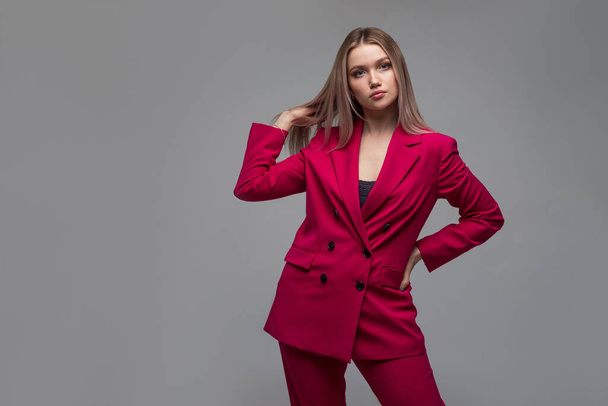 Sexy blonde in a bright raspberry pantsuit - Фото, изображение