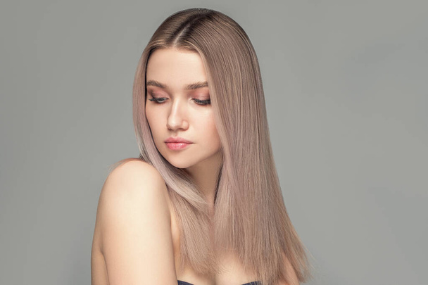 Fashion portrait of a  young woman with a natural make-up and straight blond hair - Photo, image