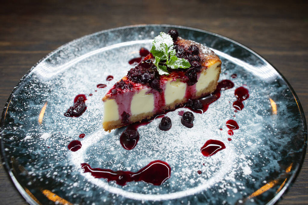 delicious creamy dessert, cheesecake with cherry jam, a leaf of mint and whipped cream - Foto, immagini