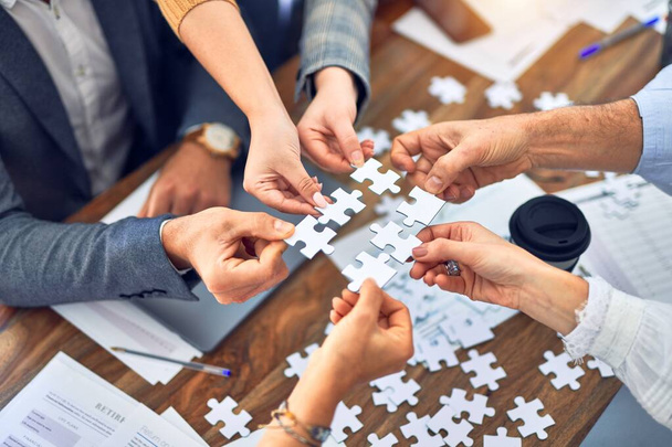 Groupe de travailleurs d'affaires avec les mains ensemble reliant des pièces de puzzle au bureau
 - Photo, image