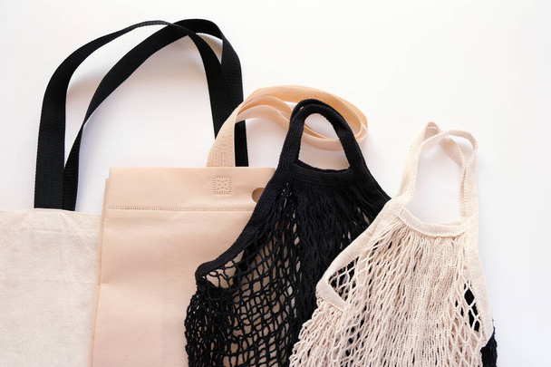 String bag, cotton bag and paper bags for free plastic purchases on a white background. Zero waste concept - Photo, image