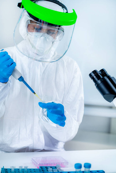 Corona-Virus-Impfstoff-Forschung, Wissenschaftlerin, die im Laboratorium des Instituts arbeitet, hält eine Mikropipette - Foto, Bild
