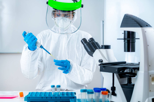Corona Virus Vaccine Research, Scientist Working in the Institute Laboratory, Holding a micro pipette - Photo, Image