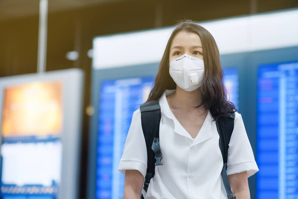 asiatico viaggiatori ragazza con chirurgico faccia maschera per protezione il covid-19 in aeroporto
 - Foto, immagini