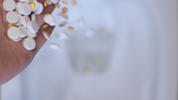 Woman hand with palm throws a lot of white pills into the toilet top view. Slow motion - Video