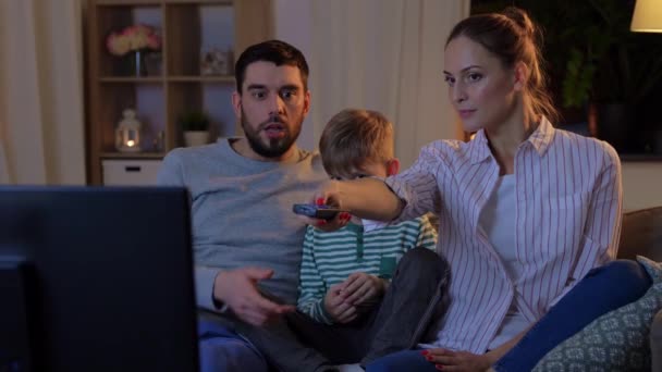 happy family watching tv at home at night - Кадри, відео