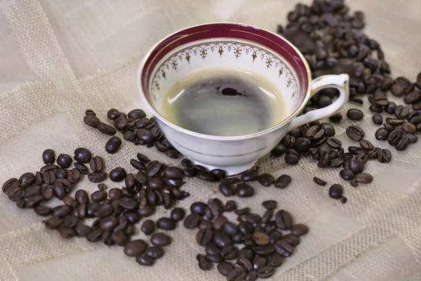 cup with hot espresso and coffee beans background - Zdjęcie, obraz
