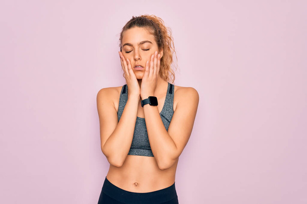 Young beautiful blonde sportswoman with blue eyes doing exercise wearing sportswear Tired hands covering face, depression and sadness, upset and irritated for problem - Photo, image