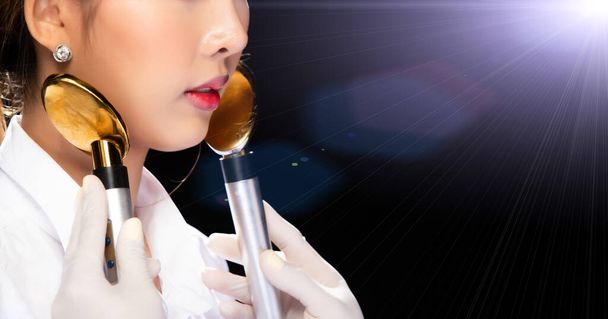 Estetista viso utilizza Golden Spoon ad alta frequenza per lifting facciale con acne anti invecchiamento elettrico e cura della pelle per restringere i pori stringendo rughe sulla donna non riconosciuta, copia spazio bokeh
 - Foto, immagini