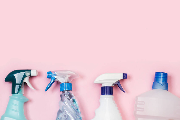Assorted cleaning products bottles on a pink background - Фото, изображение