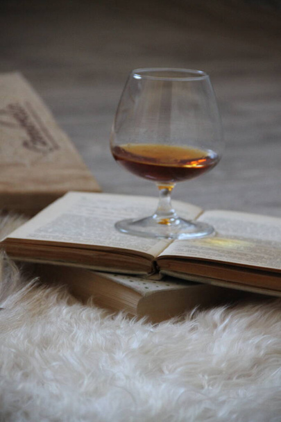 Glass of cognac and old books - Photo, Image