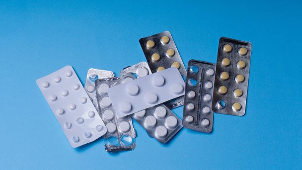 Tablets. Many tablets are on a blue background,  Drugs and pills prescription background. Pharmaceutical preparation.vitamis tablets. coronavus - Valokuva, kuva