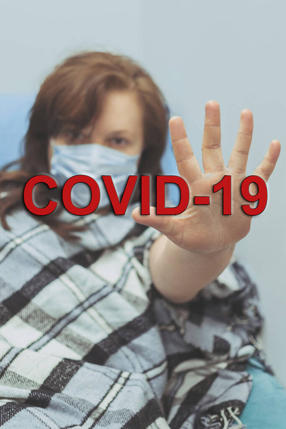 COVID-19流行性コロナウイルス疾患ウイルスの拡散のための顔マスクを着用した病気の女性家庭用隔離自動隔離顔マスクSARS-CoV-2 。コロナウイルス病2019のための顔の少女隔離マスク. - 写真・画像