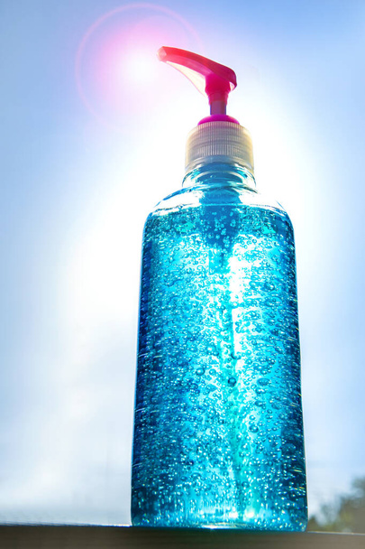  butelka żel do dezynfekcji rąk do ochrony antywirusowej korony stojącej na zewnątrz przed światłem słonecznym - Zdjęcie, obraz
