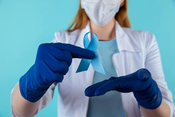 Doctor holding blue awareness ribbon, closeup view. Symbol of medical issues. - Fotoğraf, Görsel