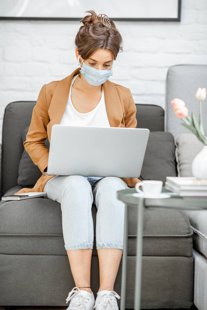 Woman in medical mask working from home - Foto, Imagen