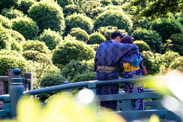 Mladý pár v kimonech tulící se na mostě - Fotografie, Obrázek