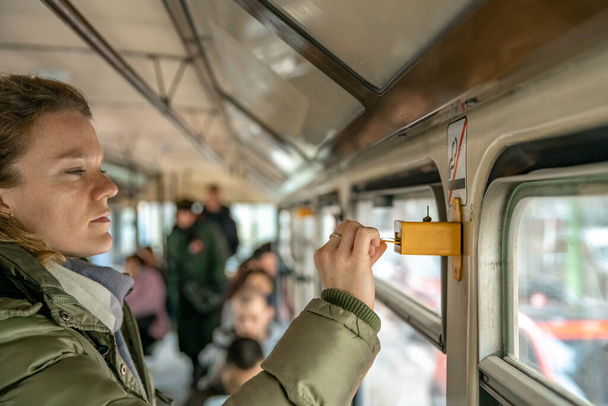 Eine Frau bezeichnet eine Fahrkarte für öffentliche Verkehrsmittel durch Schläge - Foto, Bild