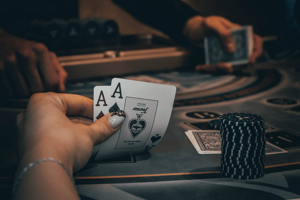 Dealer or croupier shuffles poker cards in a casino on the background of a table, chips,. Concept of poker game, game business. - Φωτογραφία, εικόνα