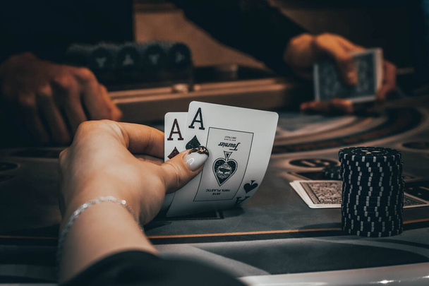 Kereskedő vagy krupié keveri póker kártyák egy kaszinóban a háttérben egy asztal, zseton,. Koncepciója póker játék, játék üzlet. - Fotó, kép