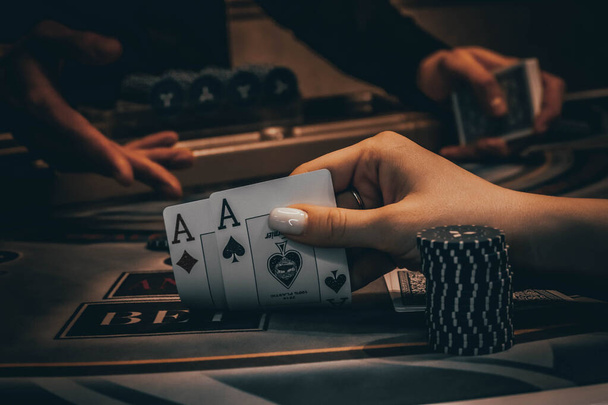 Dealer or croupier shuffles poker cards in a casino on the background of a table, chips,. Concept of poker game, game business. - 写真・画像