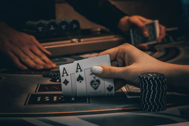 Dealer or croupier shuffles poker cards in a casino on the background of a table, chips,. Concept of poker game, game business. - Photo, image