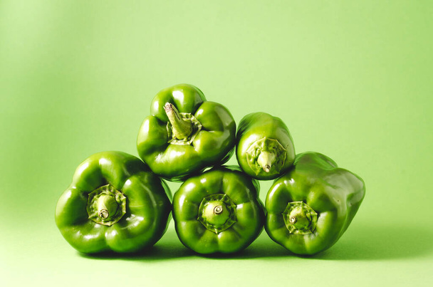 Heap of fresh green paprika pepper on green background/Heap of fresh green paprika pepper on green background, selective focus - Fotografie, Obrázek