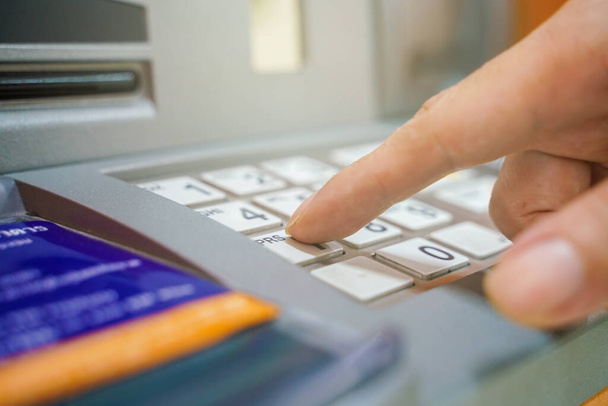Hand entering on pin pad of ATM pass code business finance - Foto, Imagen