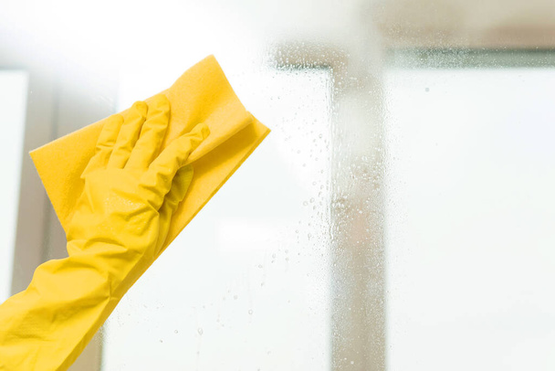 Cleaning windows with special rag. Hands with spray cleaning the window. Wet spring cleaning. - 写真・画像