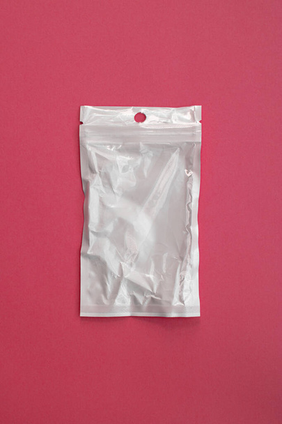 порожній прозорий пластиковий мішок із застібкою-блискавкою на рожевому фоні, застібка-блискавка для концепції ліків
 - Фото, зображення