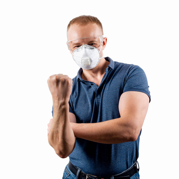 Un homme portant un masque et des lunettes montre un geste de protestation. Concept de protection contre la coronavirus. COVID-2019
. - Photo, image