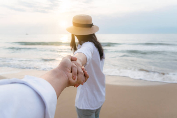 Мужчины держатся за руки женщины на пляже, чтобы быть счастливыми
 - Фото, изображение