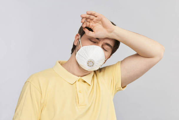 sick man in protection mask touching forehead to measure the temperature, self isolation and protect while covid-19 - Photo, Image