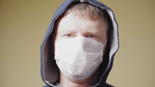 Portret van een 40-jarige man met een medisch masker. Pandemische COVID-19. Sluiten. - Video