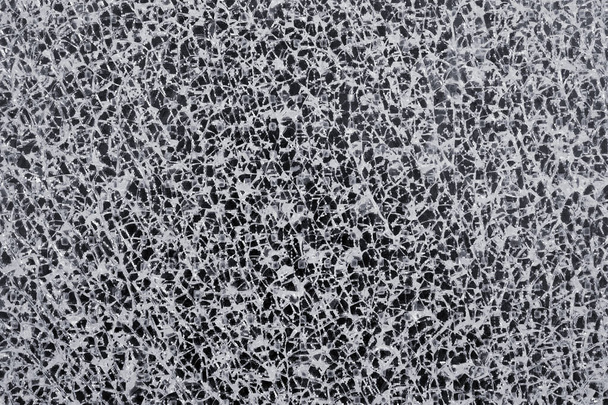 Abstrakte Textur einer zerbrochenen Glasscheibe vor schwarzem Hintergrund in Nahaufnahme   - Foto, Bild