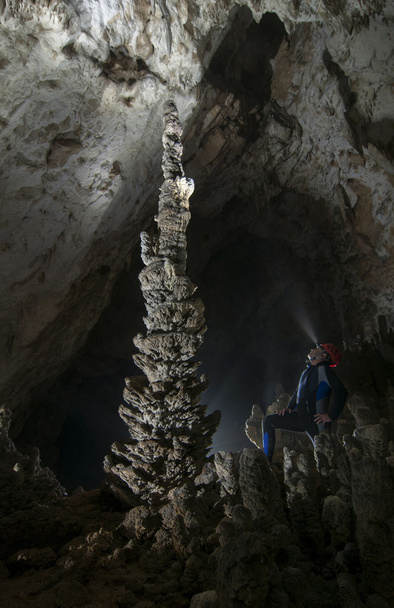 Спелеолог у печері захоплюючий великий стеагміт
 - Фото, зображення
