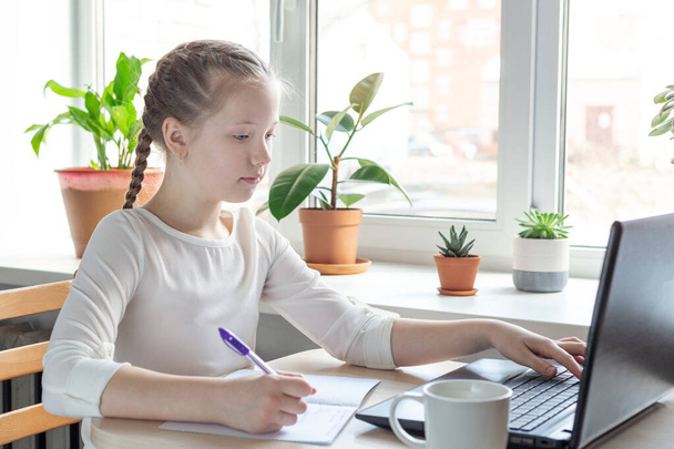 Schoolgirl studying at home using laptop. Home school, online education, home education, quarantine concept - Image - Φωτογραφία, εικόνα