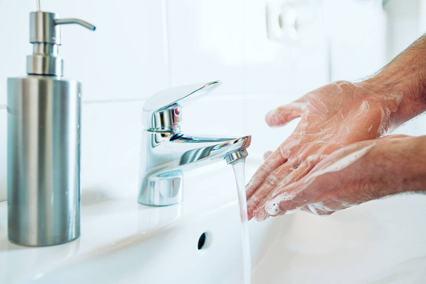 primo piano di persona accuratamente lavando mani a lavandino di bagno con sapone e acqua calda
 - Foto, immagini