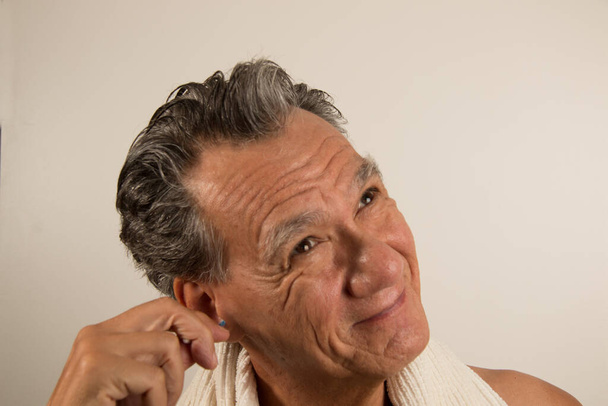 Férfi Tisztítja a fülét egy vattával  - Fotó, kép