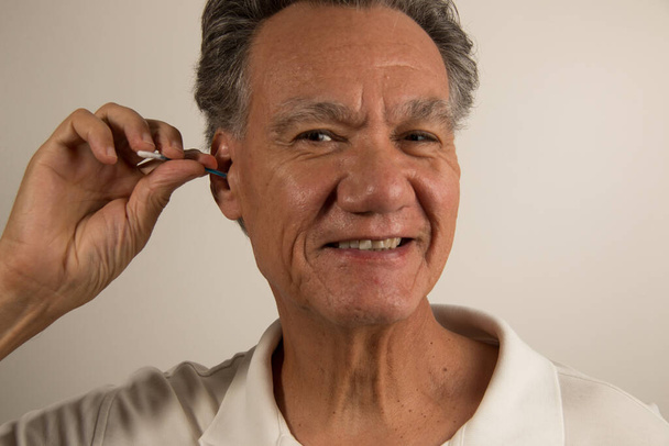 Mann reinigt sein Ohr mit Wattestäbchen  - Foto, Bild