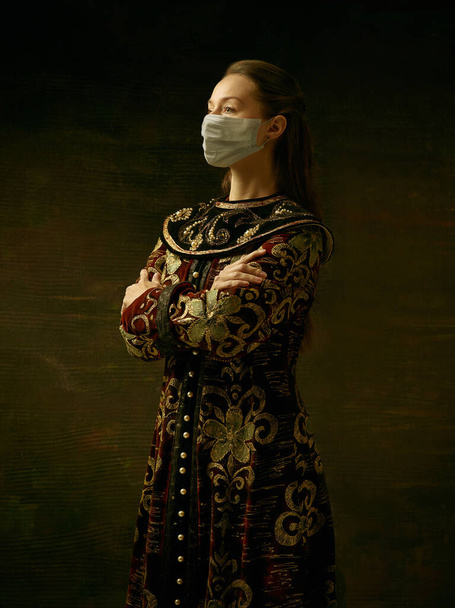 Середньовічна молода жінка, як герцогиня, одягнена в захисну маску проти коронавірусу. - Фото, зображення