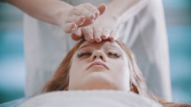 Massage - woman masseuse is kneading her clients face with palms - Photo, Image