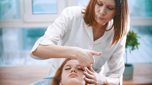 Massage - massothérapeute pince le visage d'une femme
 - Photo, image