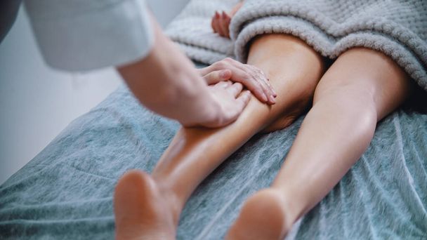 Massage - Massage-Meister massiert schlanke Beine einer Frau - Foto, Bild