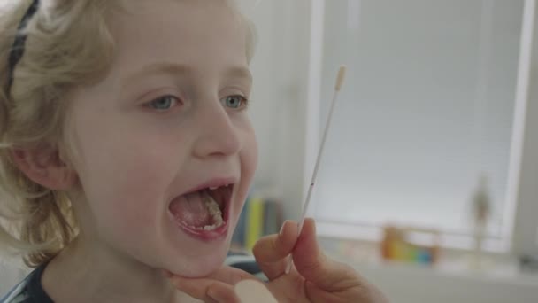 Slow Motion Close Up Handheld Shot Of Young Boy Having Swab Taken From Inside Of Mouth To Test For Coronavirus (Corvid19) - Filmagem, Vídeo