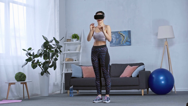 Sportlerin mit vr-Headset im Wohnzimmer - Filmmaterial, Video
