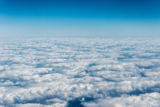 Вид зверху на білі хмари над землею або водою. Горизонтальна рамка
 - Фото, зображення