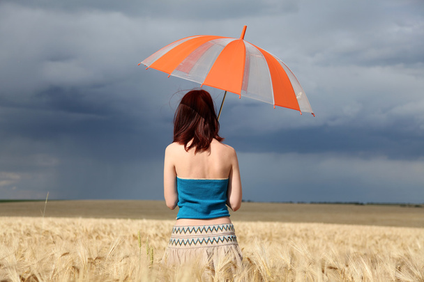 Girl with umbrella at field in rainy day. - Photo, Image
